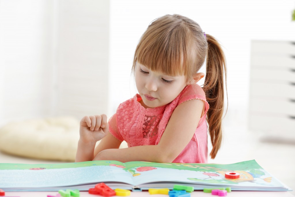 Little girl reading a story book