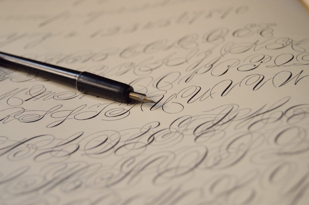 pen on top of paper written with calligraphy