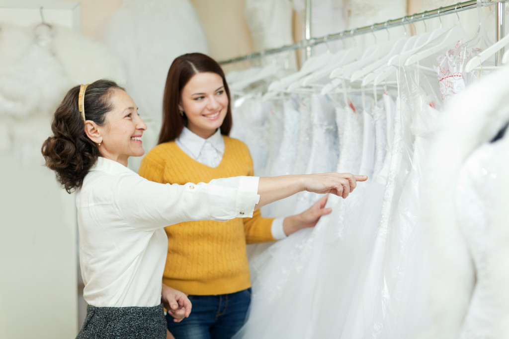 bride to be with an assistant buying a dress