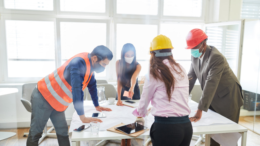 woman leading the discussion with blueprints on the table