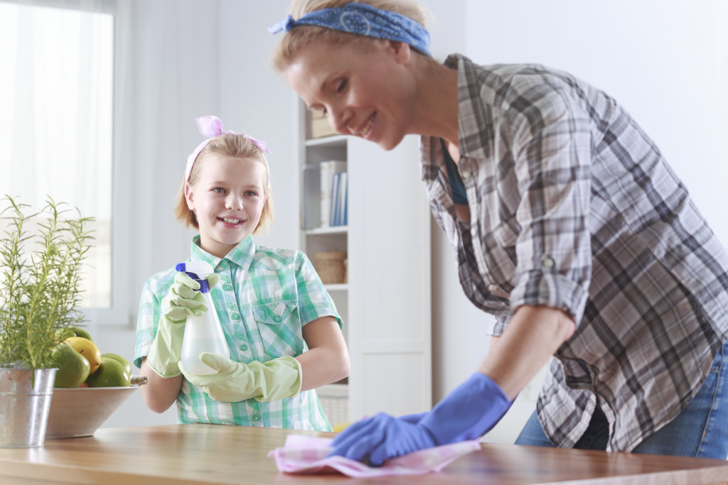 woman cleaning with daughter helping her