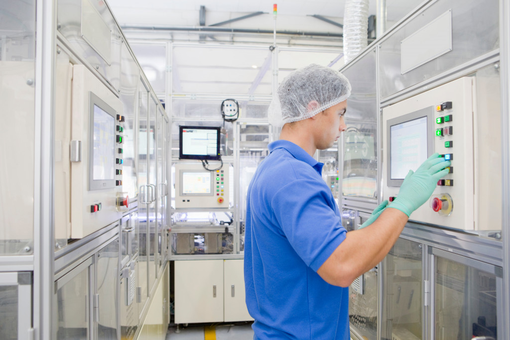 A woker in the factory floor operating an automated machine