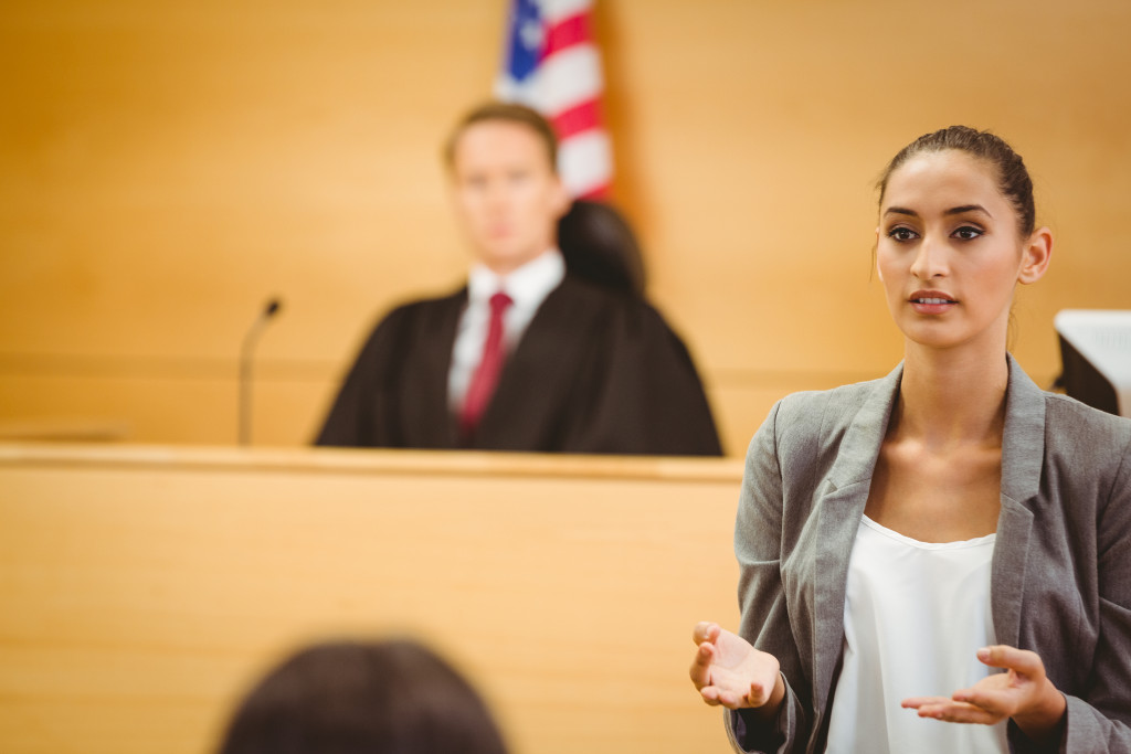 a woman talking in front of a male judge at court