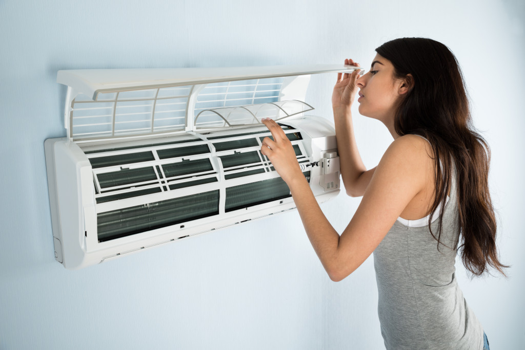 Woman fixing air conditioner