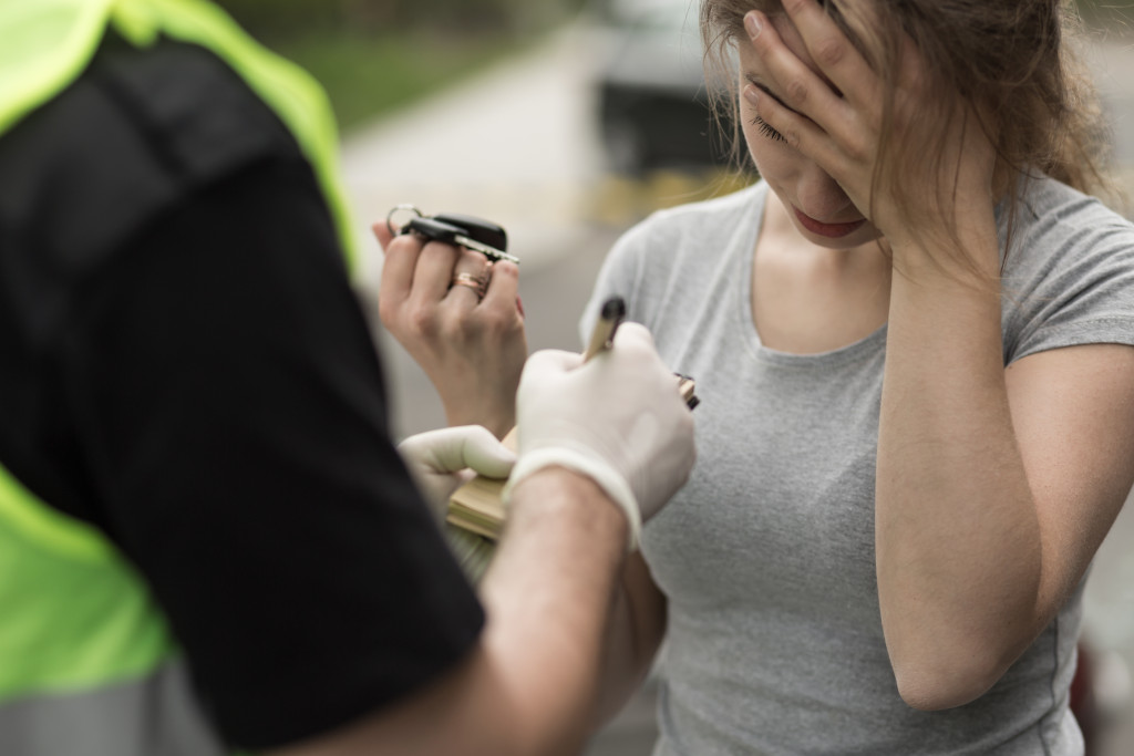 a woman handing car keys to an officer