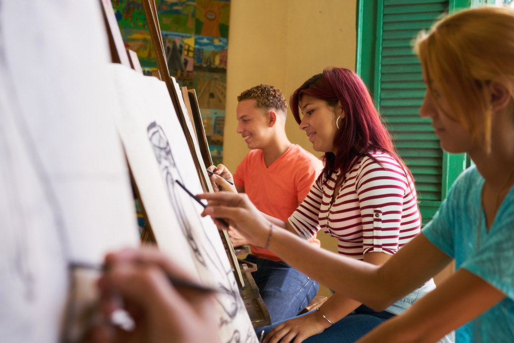 People sketching on canvases in an art class