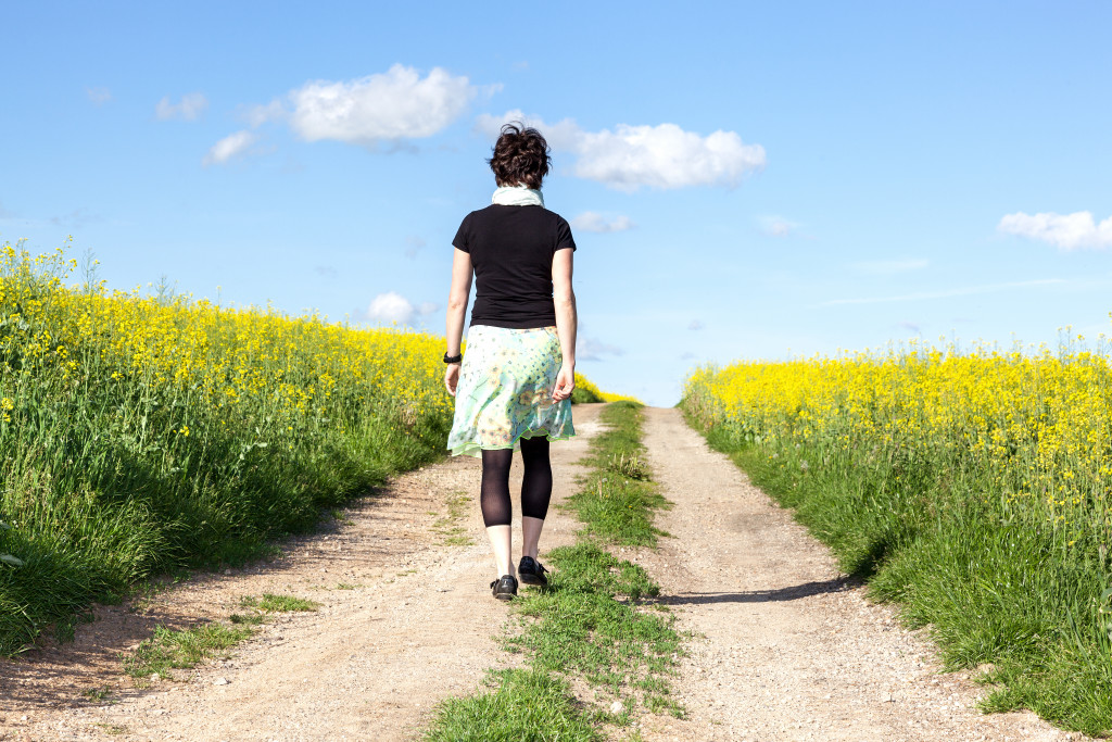 A woman walking on a dirt road in nature