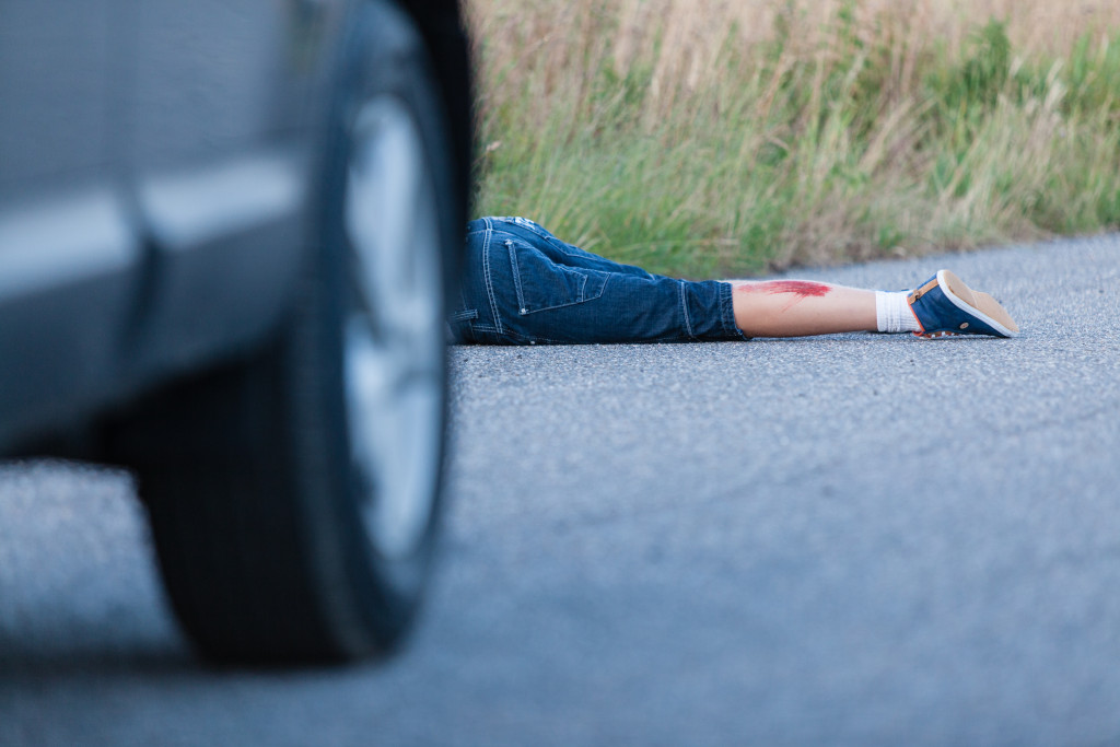 An injured person lying on the road after a collision