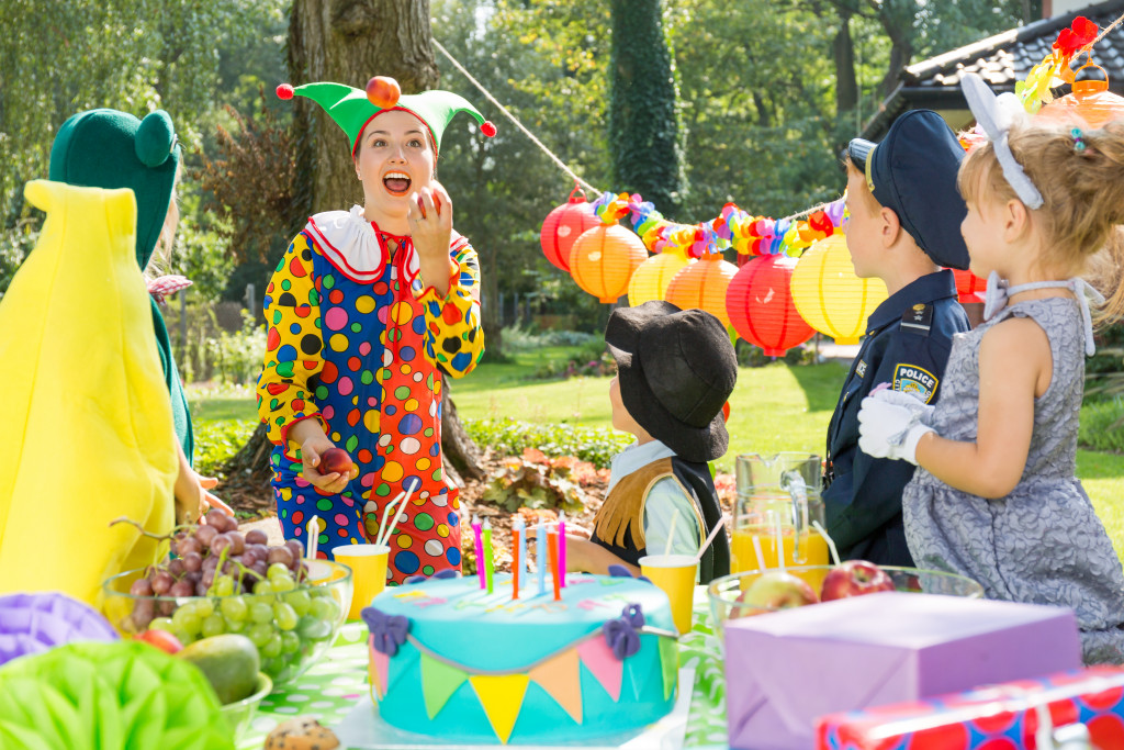 kids happy to see clown in costume in the backyard party